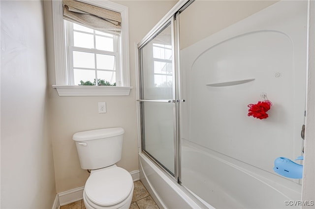 bathroom featuring shower / bath combination with glass door, tile patterned floors, and toilet