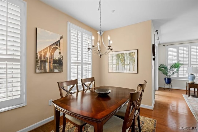 dining area featuring hardwood / wood-style flooring and a notable chandelier