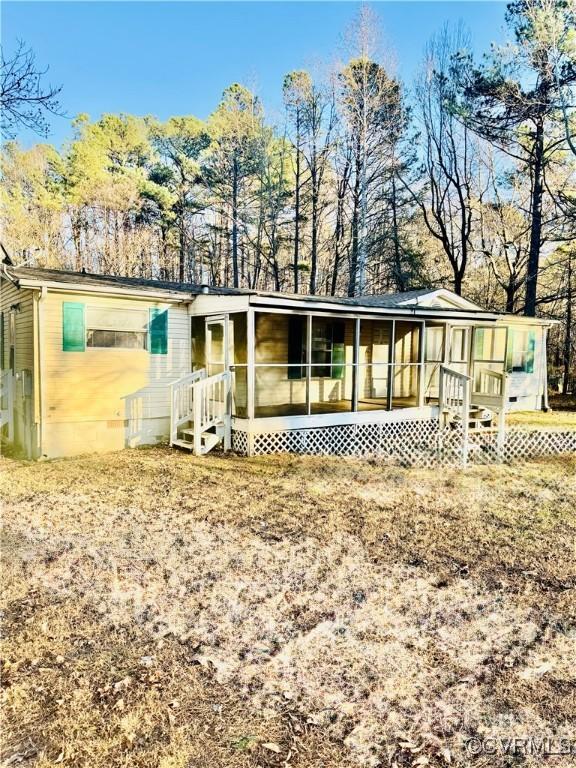 rear view of property featuring a sunroom