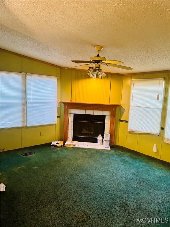 271 Walnut Hill Rd, Crewe, VA 23930 - unfurnished living room featuring a tile fireplace, a textured ceiling, ceiling fan, and carpet flooring