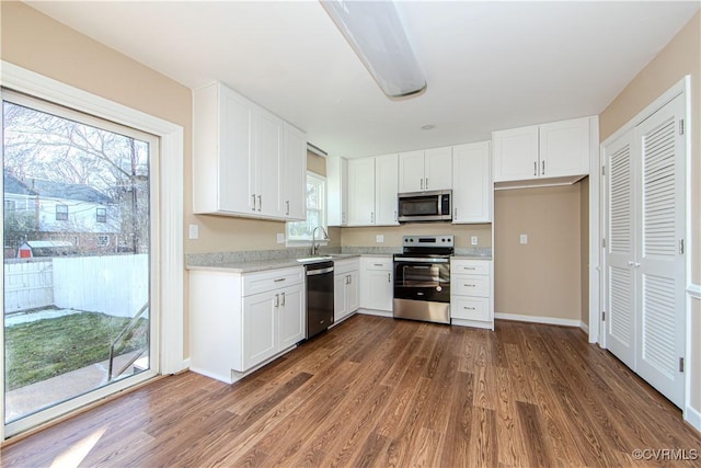 kitchen featuring white cabinetry, appliances with stainless steel finishes, dark hardwood / wood-style flooring, and sink