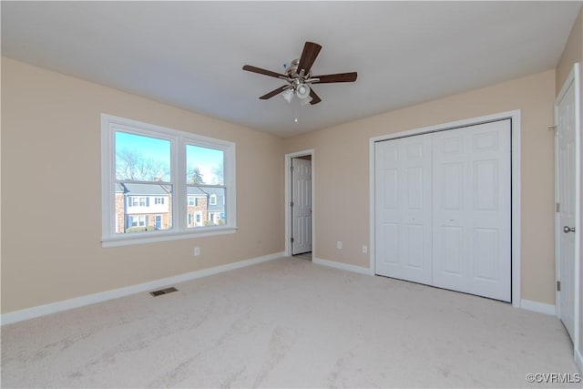 unfurnished bedroom with light colored carpet, ceiling fan, and a closet