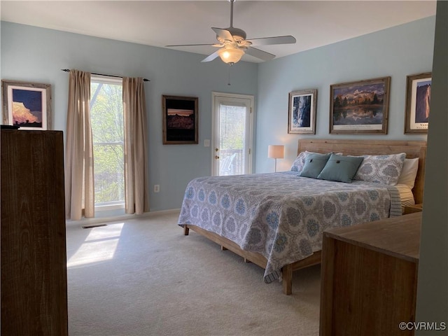 carpeted bedroom featuring ceiling fan, access to exterior, and multiple windows