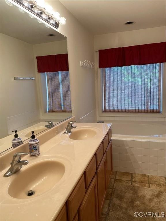 bathroom with tiled bath and vanity