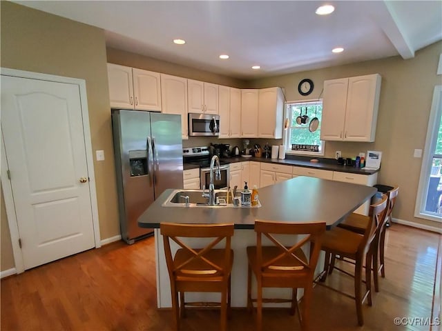 kitchen featuring white cabinets, sink, stainless steel appliances, and light hardwood / wood-style flooring