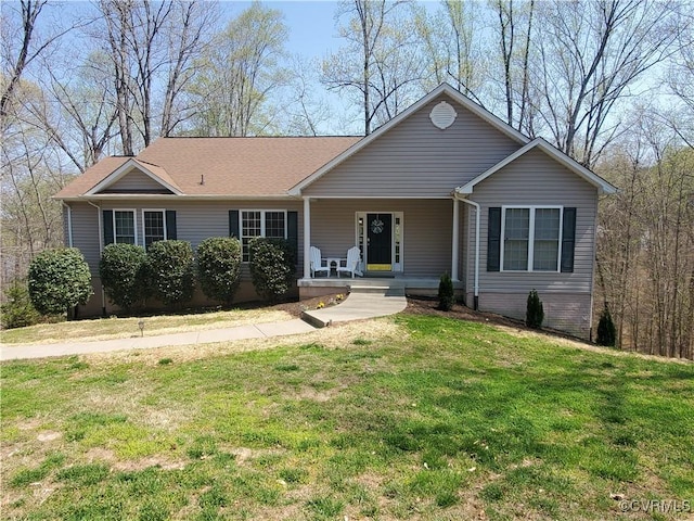 ranch-style home featuring covered porch and a front yard