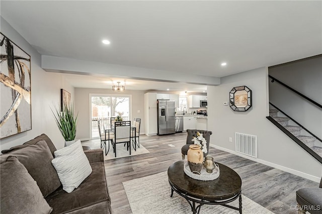 living room with a notable chandelier and hardwood / wood-style flooring