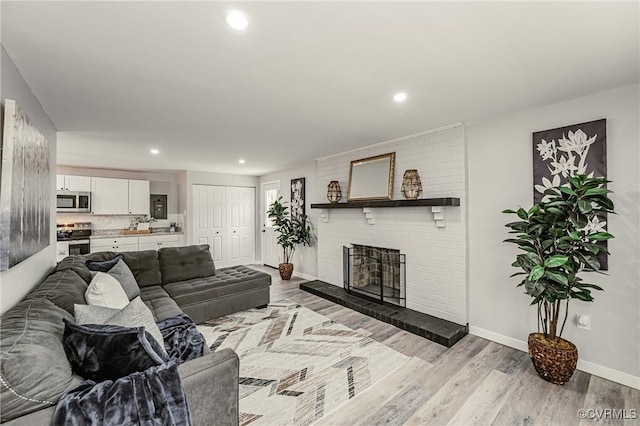 living room with light wood-type flooring and a fireplace