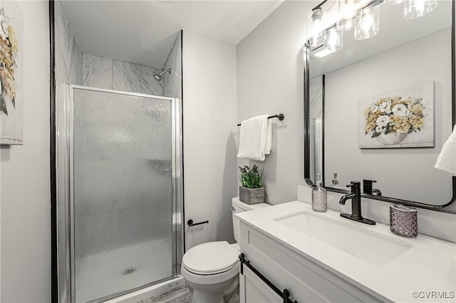 bathroom with toilet, a shower with shower door, and vanity