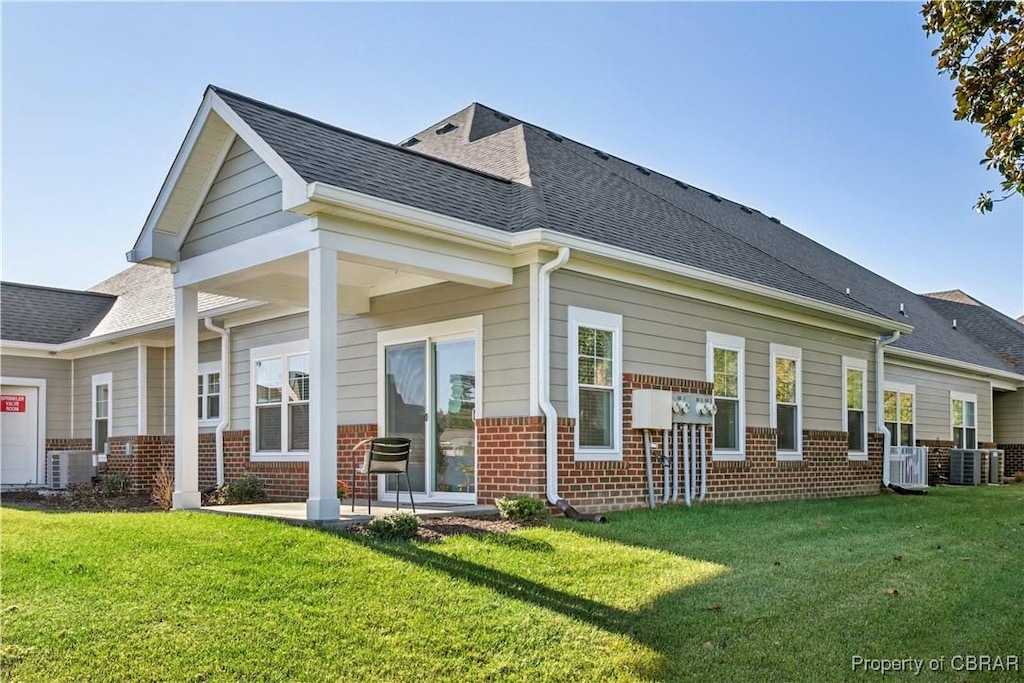 back of property with a patio area and a lawn