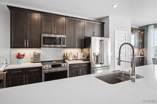 kitchen with sink, decorative backsplash, dark brown cabinets, and stainless steel appliances