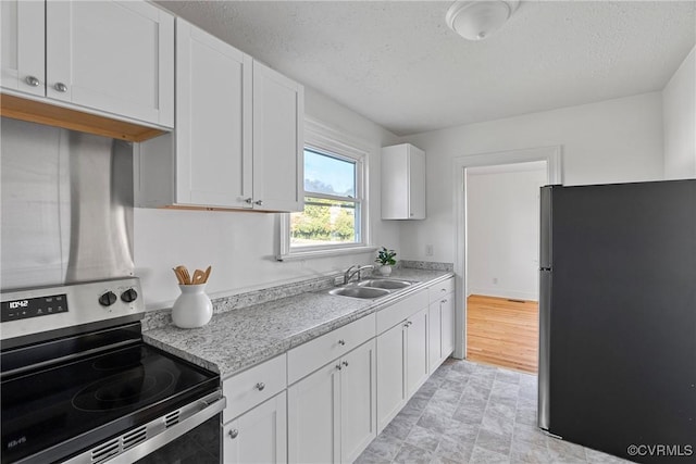 kitchen featuring white cabinets, sink, stainless steel appliances, and a textured ceiling