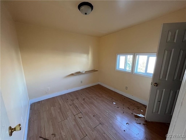 empty room featuring vaulted ceiling and light wood-type flooring