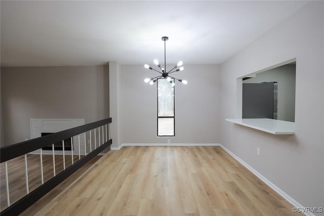 unfurnished room featuring light hardwood / wood-style floors and a chandelier