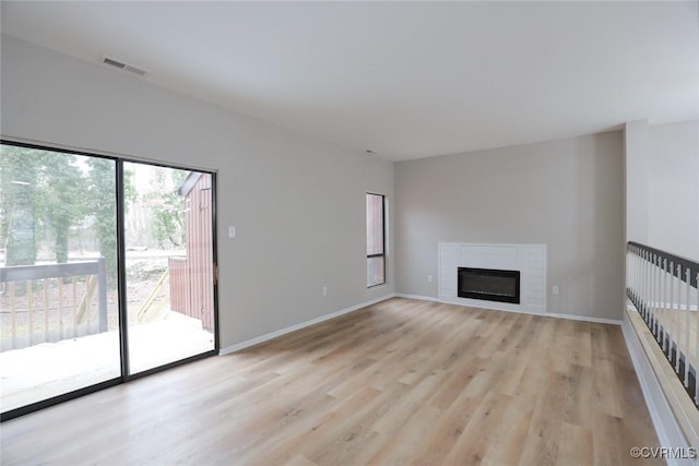 unfurnished living room with light wood-type flooring and a fireplace