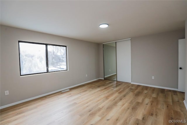 unfurnished bedroom with a closet and light hardwood / wood-style floors