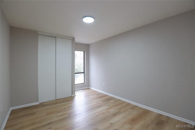 unfurnished bedroom with light wood-type flooring and a closet