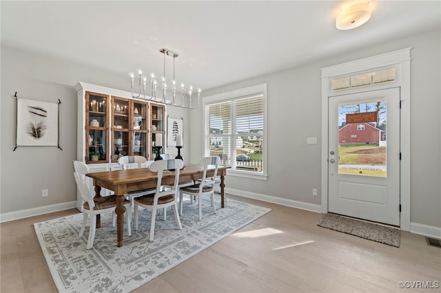 dining space featuring an inviting chandelier and light hardwood / wood-style floors