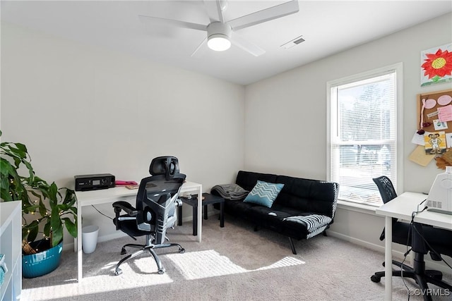 carpeted office space with ceiling fan and a wealth of natural light