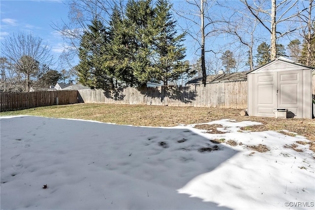 snowy yard featuring a storage unit