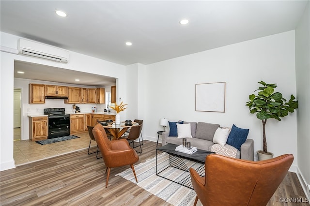 living room featuring an AC wall unit and light hardwood / wood-style floors