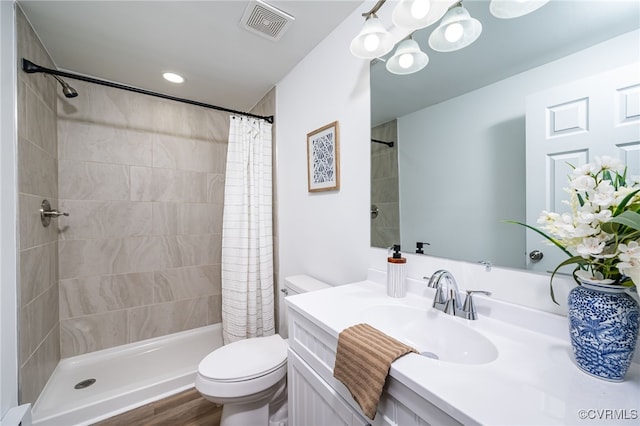 bathroom featuring toilet, hardwood / wood-style flooring, vanity, and curtained shower