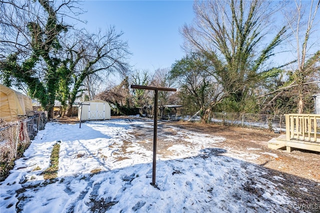 snowy yard featuring a storage shed