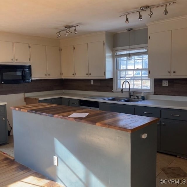 kitchen with pendant lighting, a kitchen island, white cabinetry, sink, and light tile patterned flooring