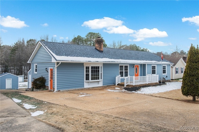 single story home featuring covered porch and a storage unit