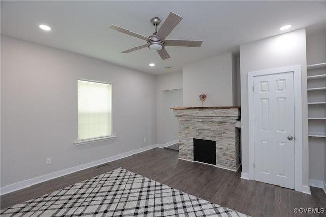 unfurnished living room featuring ceiling fan, a fireplace, and dark hardwood / wood-style floors