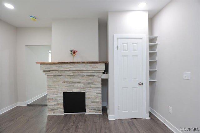 unfurnished living room with dark hardwood / wood-style flooring and a fireplace