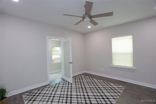 empty room with ceiling fan and dark hardwood / wood-style flooring