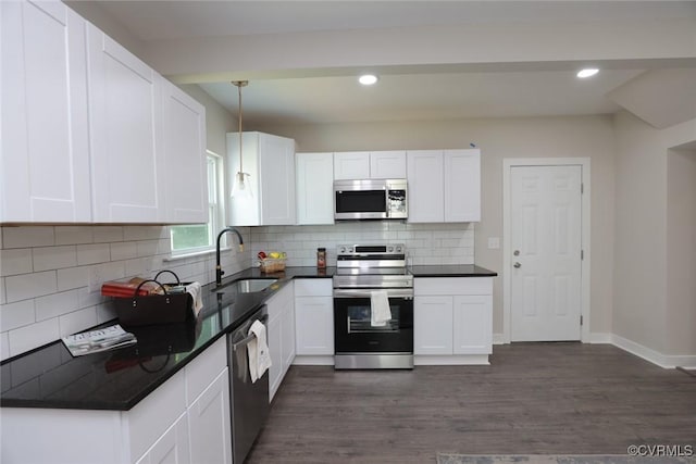 kitchen with stainless steel appliances, pendant lighting, white cabinetry, and sink