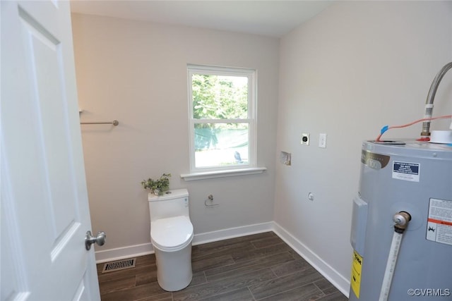 interior space with electric water heater, laundry area, baseboards, wood tiled floor, and electric dryer hookup