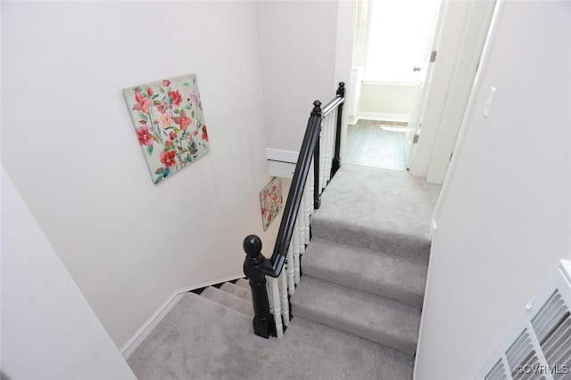 staircase featuring carpet flooring and baseboards