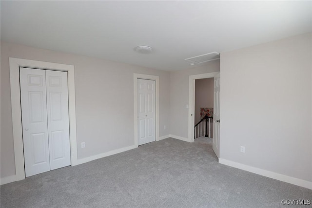 unfurnished bedroom featuring light carpet, two closets, and baseboards