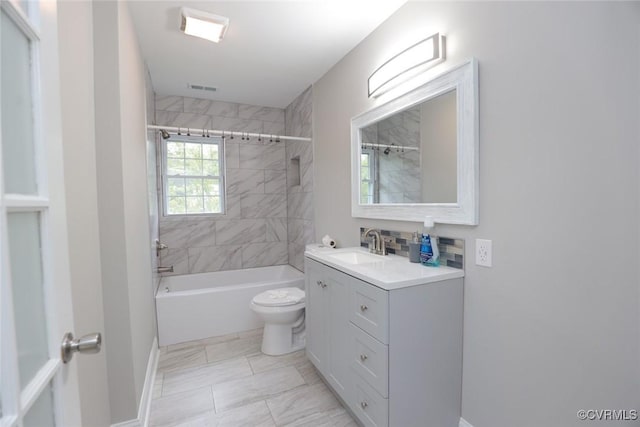 full bathroom featuring toilet, tiled shower / bath, and vanity