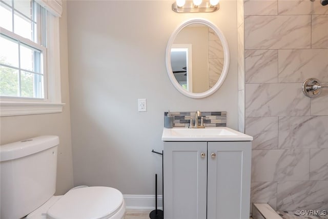 bathroom featuring toilet, vanity, and decorative backsplash