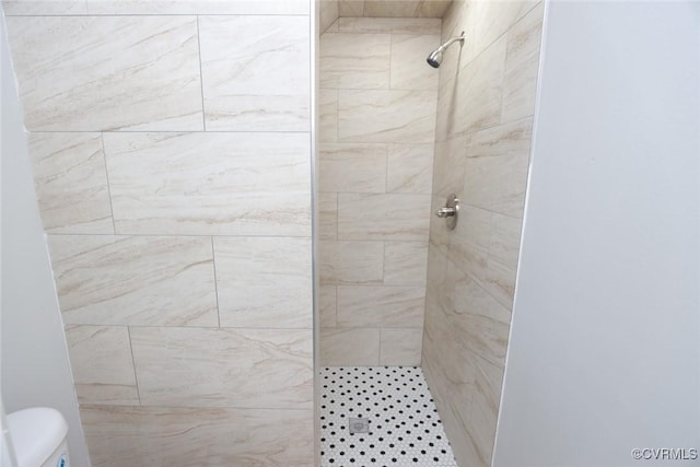 bathroom featuring toilet and a tile shower