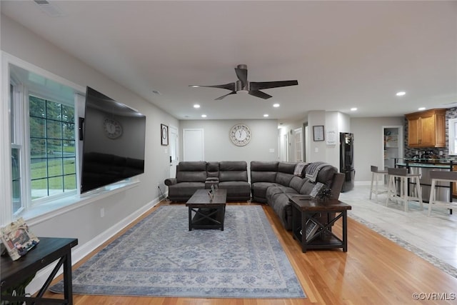 living room featuring light wood-type flooring and ceiling fan