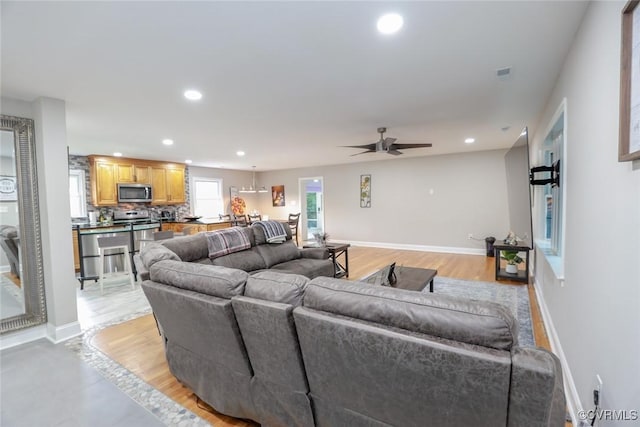 living room with ceiling fan and light hardwood / wood-style floors