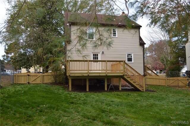 back of property featuring a deck and a lawn