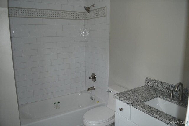 full bathroom with toilet, vanity, and tiled shower / bath