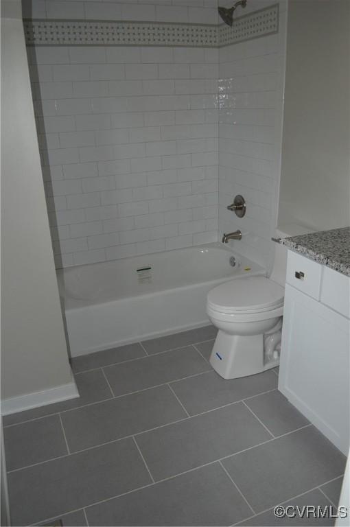 full bathroom featuring toilet, tiled shower / bath combo, tile patterned flooring, and vanity