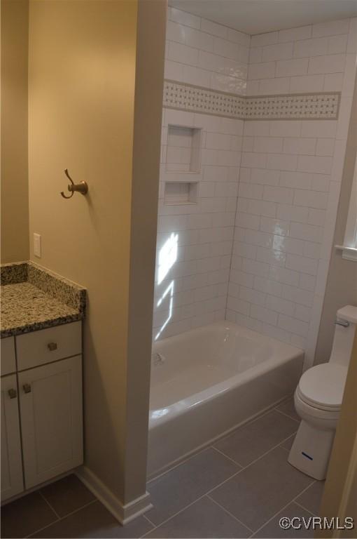 full bathroom featuring toilet, tile patterned flooring, tiled shower / bath combo, and vanity