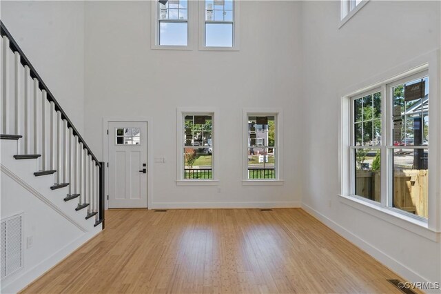 entryway with light wood-type flooring and a high ceiling