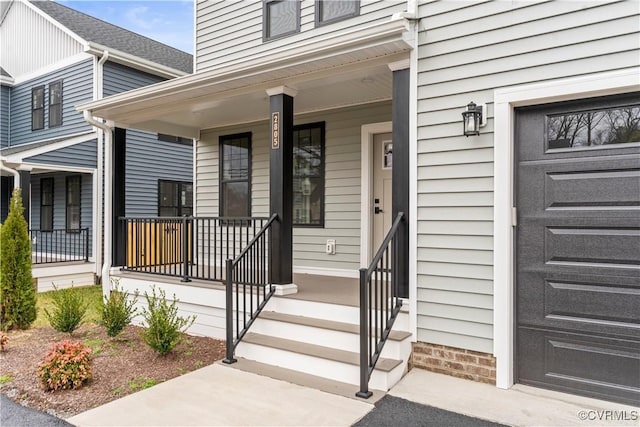 entrance to property with covered porch and a garage