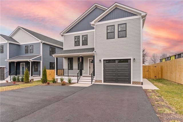 view of front of property featuring fence, driveway, an attached garage, covered porch, and board and batten siding