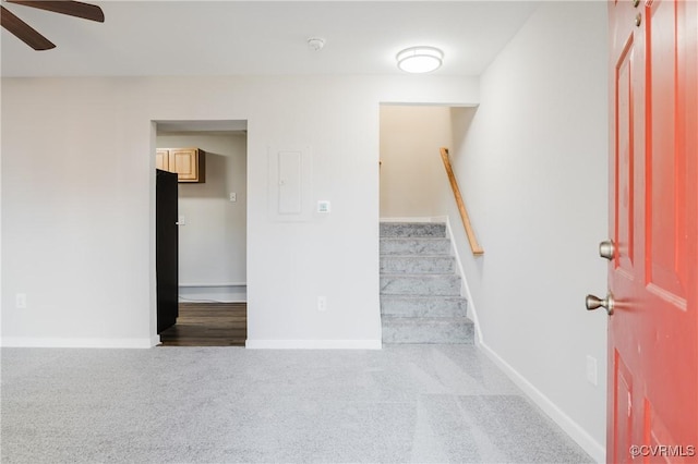 stairway with ceiling fan and carpet