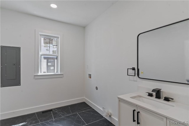 clothes washing area featuring cabinets, sink, hookup for a washing machine, electric panel, and gas dryer hookup